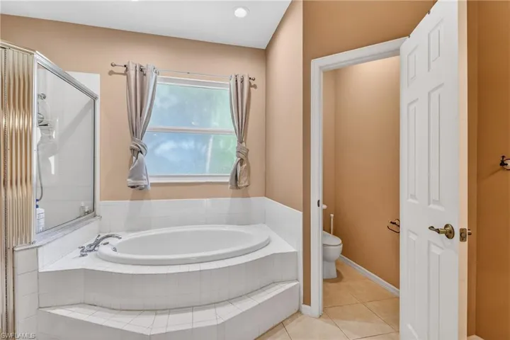 Bathroom featuring a garden tub, tile patterned floors, and a shower stall