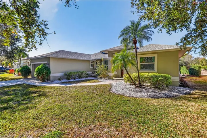 Single story home with an attached garage, stucco siding, a front lawn, and a shingled roof