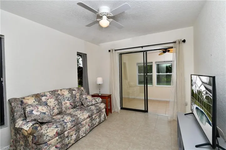 Bedroom 3 featuring a ceiling fan and sliding glass doors leading to enclosed lanai.