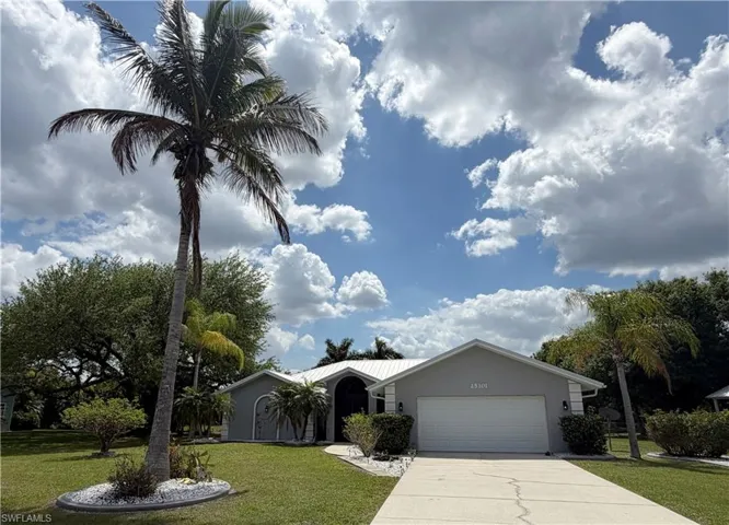 Ranch-style house featuring a front yard, an attached garage, stucco siding, and concrete driveway