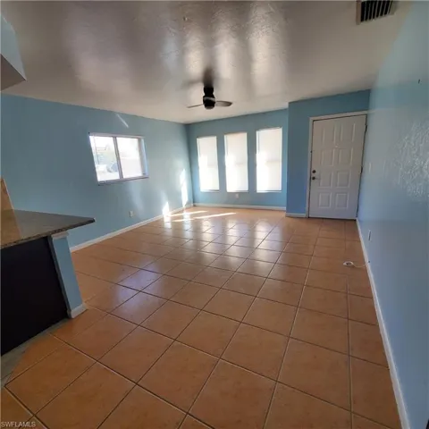 Unfurnished living room featuring light tile patterned floors and a ceiling fan