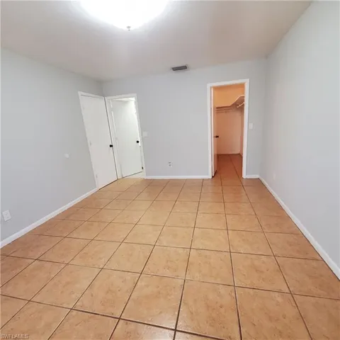 Unfurnished bedroom with light tile patterned flooring and a spacious closet