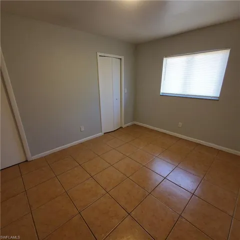 Unfurnished bedroom with light tile patterned floors and a closet