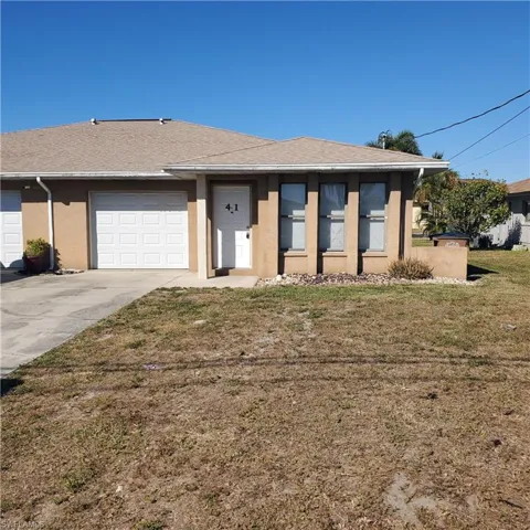 Ranch-style house featuring stucco siding, a front yard, driveway, a shingled roof, and an attached garage