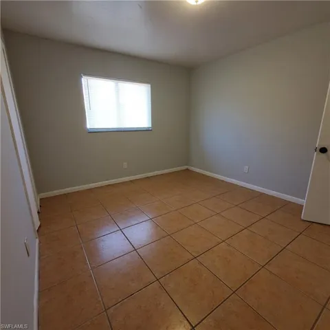 Spare room with light tile patterned floors and baseboards