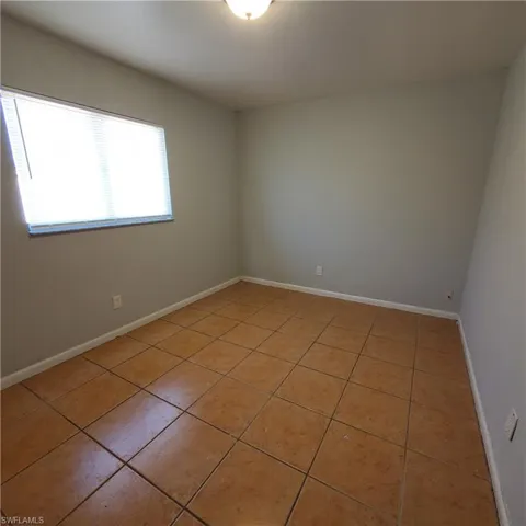Unfurnished room featuring light tile patterned floors and baseboards