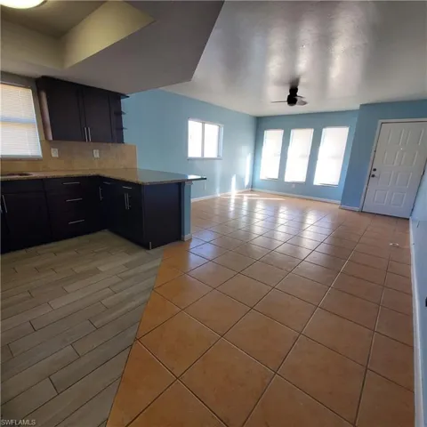 Kitchen with a peninsula, open shelves, open floor plan, decorative backsplash, and plenty of natural light
