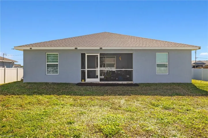 Back of house with a sunroom and a lawn