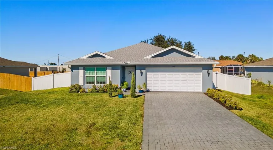 Ranch-style home featuring a garage and a front yard