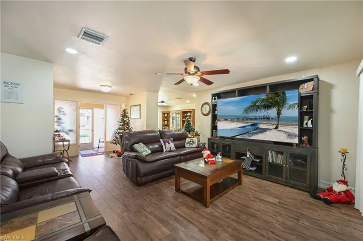 Living area with recessed lighting, dark wood-style flooring, and a ceiling fan