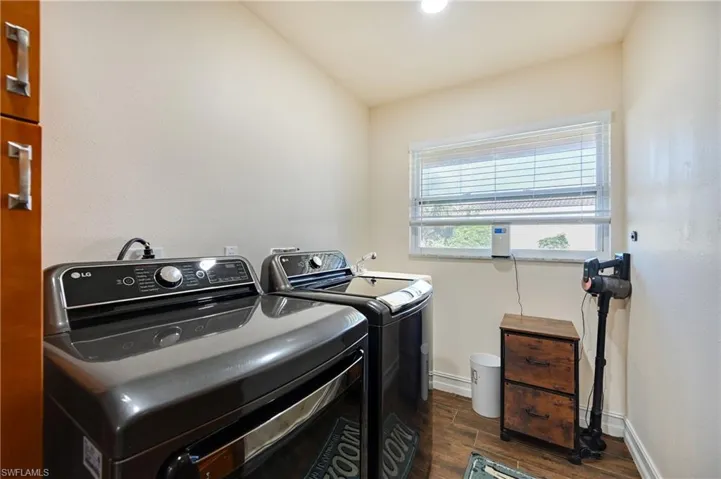 Washroom with wood tiled floors and independent washer and dryer