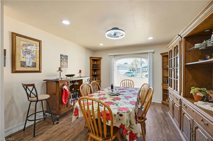 Dining space with dark wood-type flooring and recessed lighting