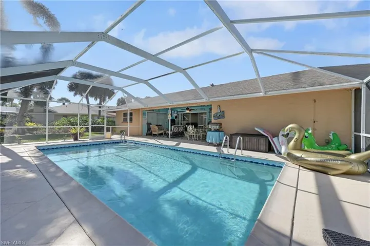 Outdoor pool featuring a sunroom, a lanai, and a patio area