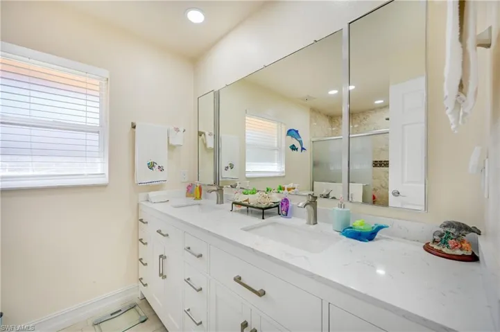 Bathroom featuring double vanity, a stall shower, and recessed lighting