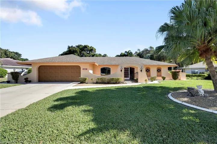 Ranch-style house with concrete driveway, a front lawn, stucco siding, and an attached garage