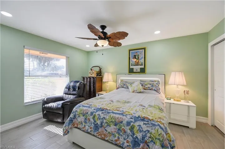 Bedroom featuring wood tiled floors, ceiling fan, recessed lighting, and a closet