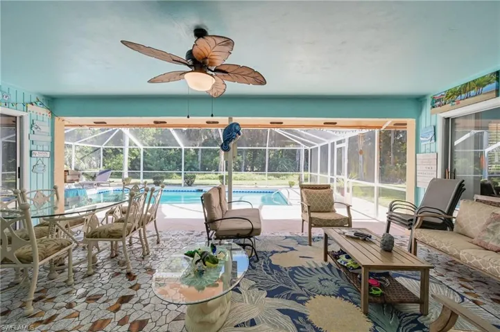 View of patio featuring a sunroom, glass enclosure, an outdoor pool, and ceiling fan