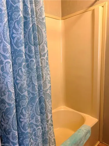 Full bathroom featuring shower / bathtub combination with curtain