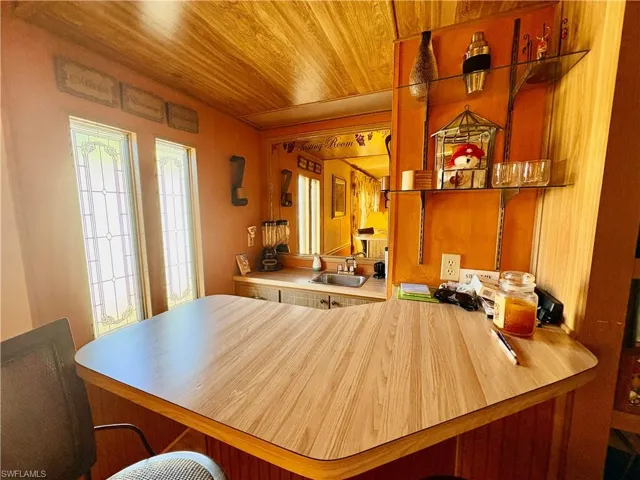 Kitchen featuring wood ceiling, light countertops, a peninsula, and a kitchen breakfast bar