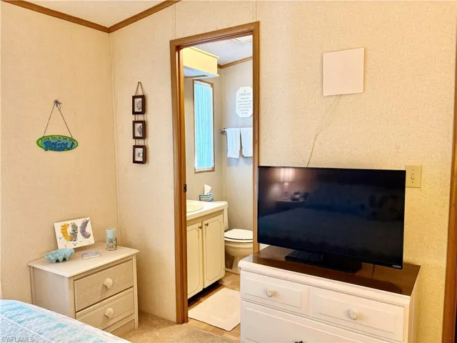 Bedroom featuring crown molding and light carpet