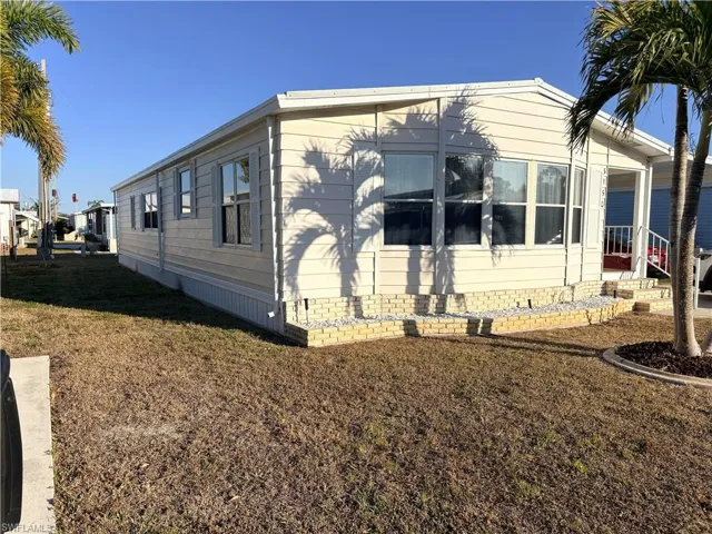View of property exterior featuring a lawn