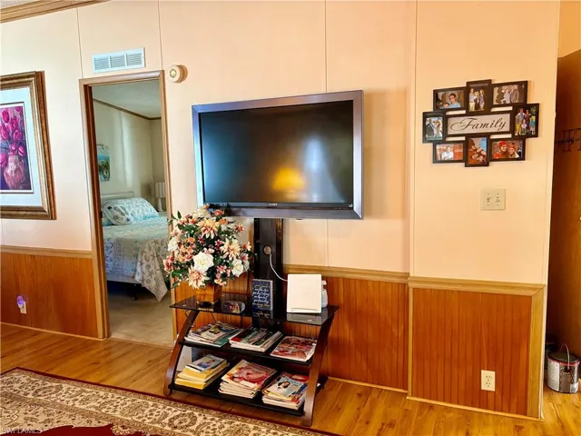 Detailed view of wainscoting, wood walls, wood finished floors, and a decorative wall