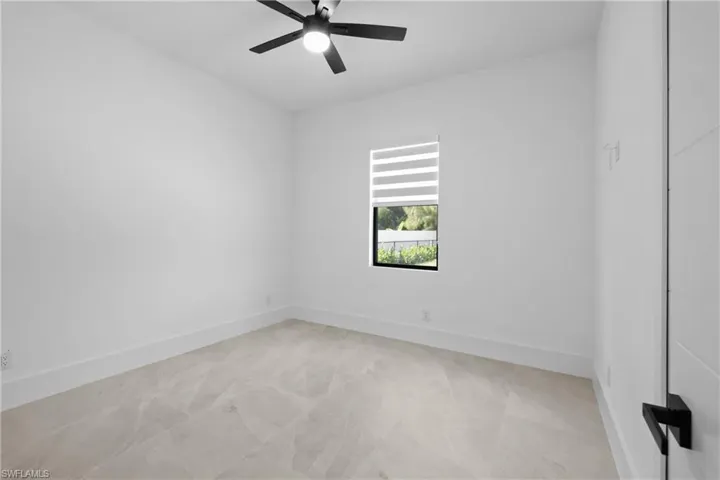 Unfurnished room featuring a ceiling fan and baseboards