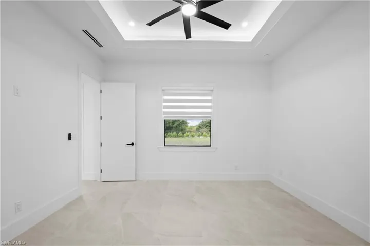 Spare room featuring a tray ceiling, ceiling fan, and recessed lighting