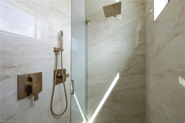 Full bathroom with a marble finish shower