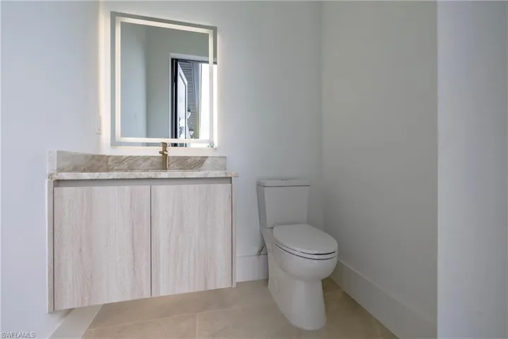 Half bathroom with vanity and light tile patterned floors