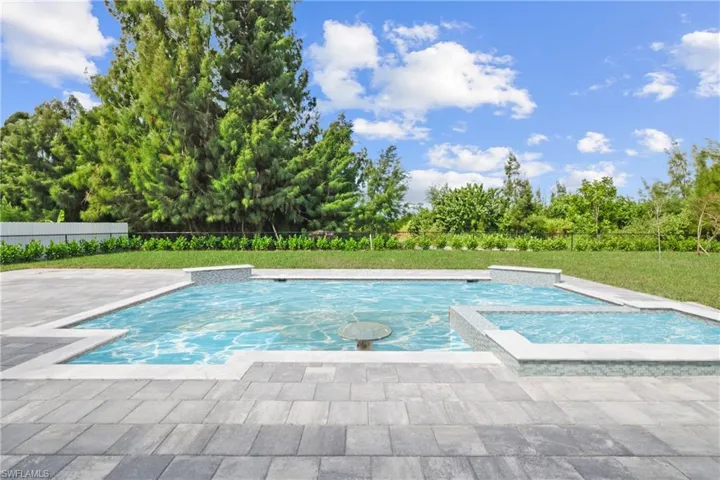 View of pool with a patio area and a pool with connected hot tub