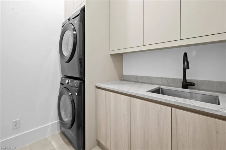Laundry area with cabinet space and stacked washing machine and dryer