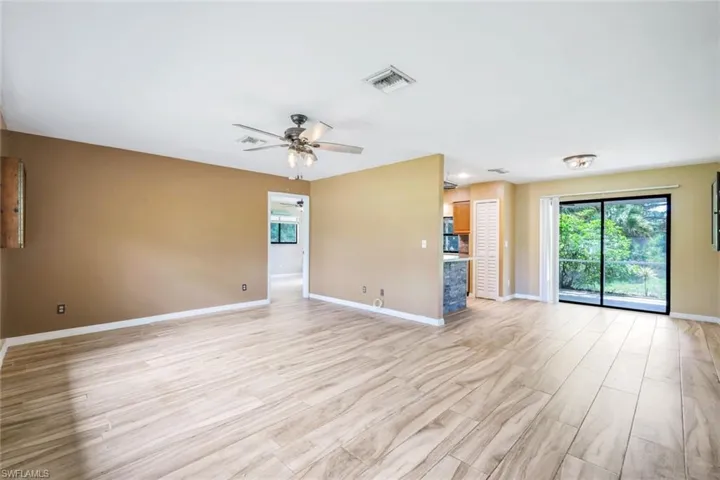 Unfurnished living room with light wood-type flooring and ceiling fan