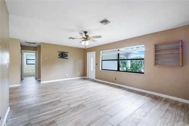 Unfurnished room featuring ceiling fan, light hardwood / wood-style flooring, and a wealth of natural light