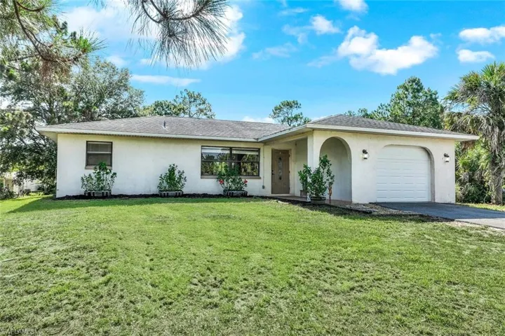Single story home with a garage and a front yard