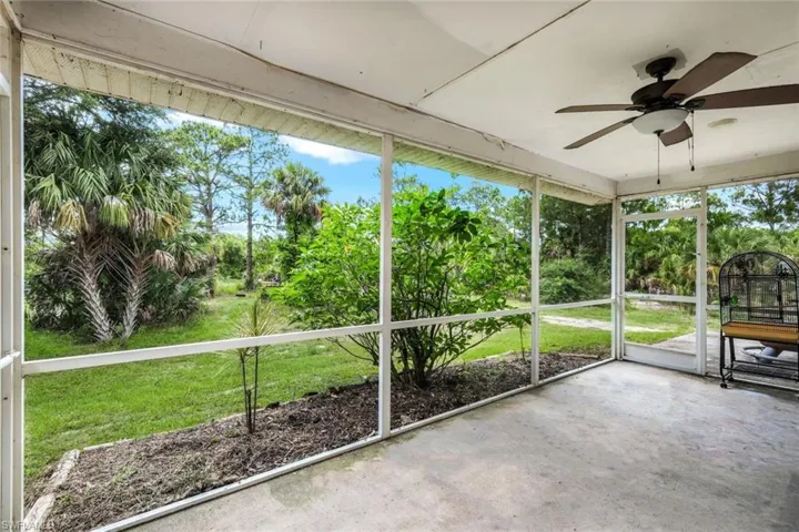 Unfurnished sunroom featuring ceiling fan