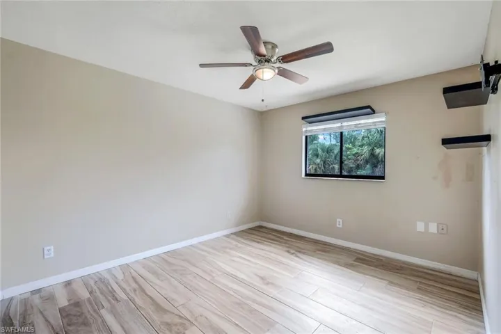 Empty room with ceiling fan and light hardwood / wood-style flooring