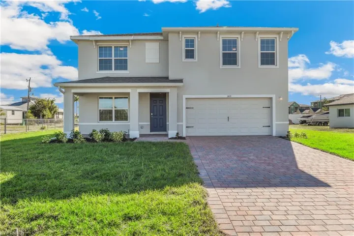 MODEL - View of front of house with stucco siding, decorative driveway, a garage, and a porch
