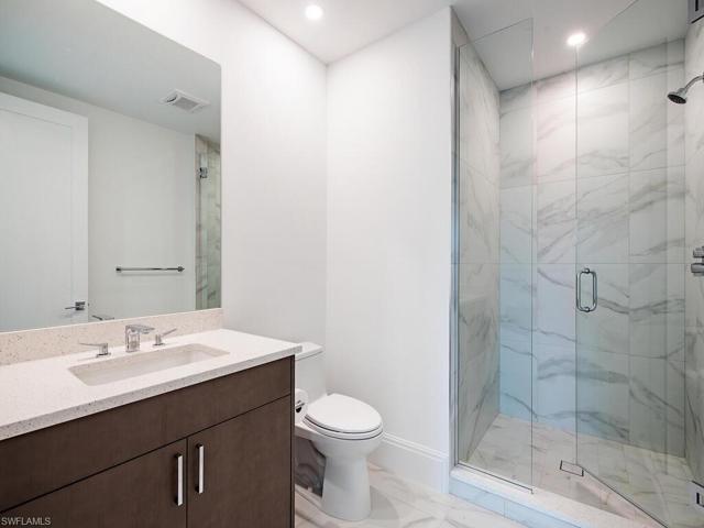 Ensuite 3rd Bedroom Bath features beautiful step-in frameless shower with large quartz countertop.