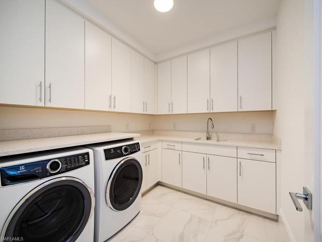 Spacious Laundry Room with lots of storage, countertops, and sink.