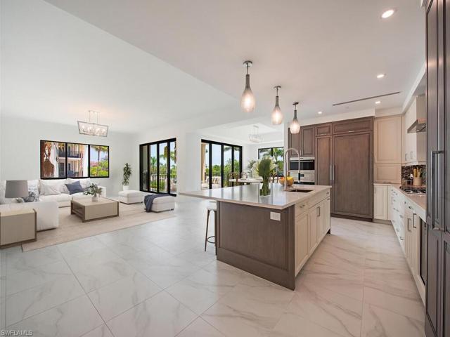 Great Room/Living Room/Kitchen/Dining Room feature beautiful tile floors throughout the condo. Luxury finishes and high-end appliances, quartz countertops, custom cabinetry. Open, airy, and bright, you feel right at home for a Naples Paradise get-away or to entertain with ease.
