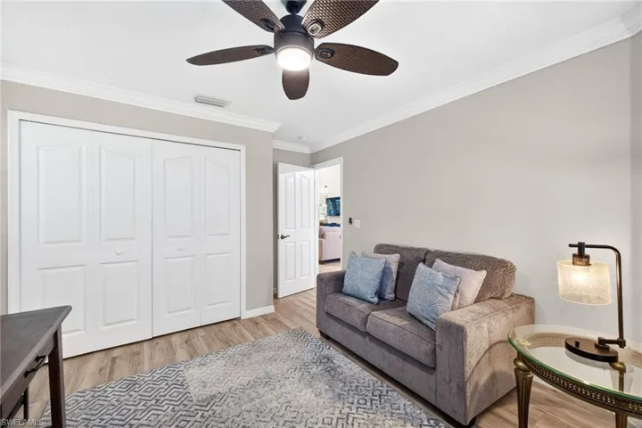 Living area with ornamental molding, light wood finished floors, and ceiling fan
