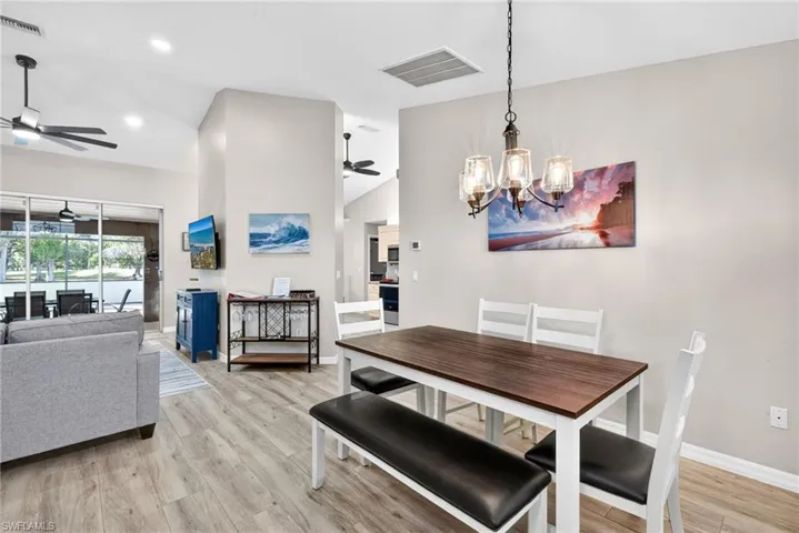 Dining area featuring light wood finished floors, a chandelier, recessed lighting, and a ceiling fan