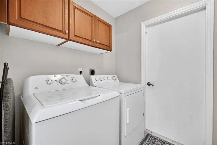 Washroom with cabinet space and washing machine and dryer