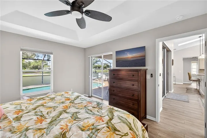 Bedroom featuring access to exterior, light wood finished floors, and multiple windows
