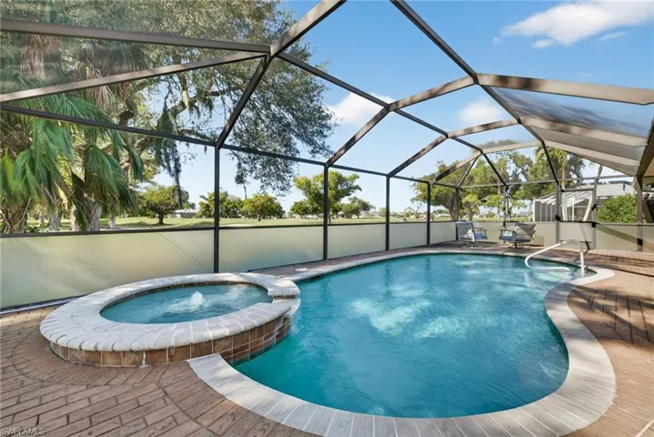 View of pool featuring a pool with connected hot tub, a lanai, a sunroom, and a patio