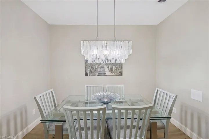 Dining area with wood finished floors and suspended lighting
