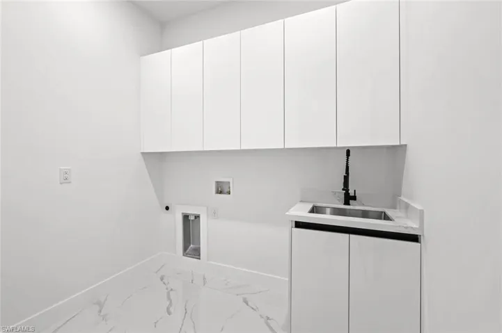 Laundry room with hookup for a washing machine, sink, cabinets, and hookup for an electric dryer