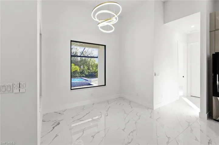 Unfurnished room featuring an inviting chandelier