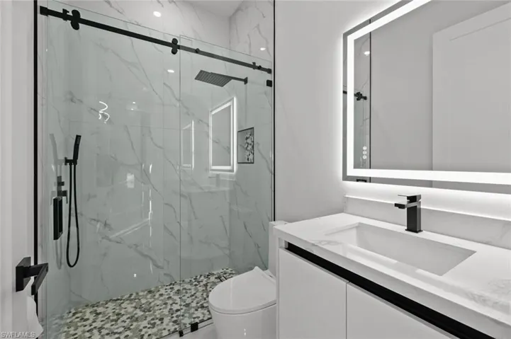Bathroom featuring vanity, toilet, and walk in shower